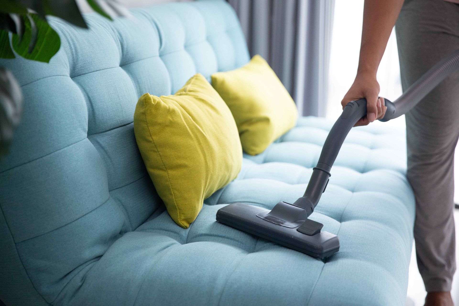 Vacuuming a blue sofa