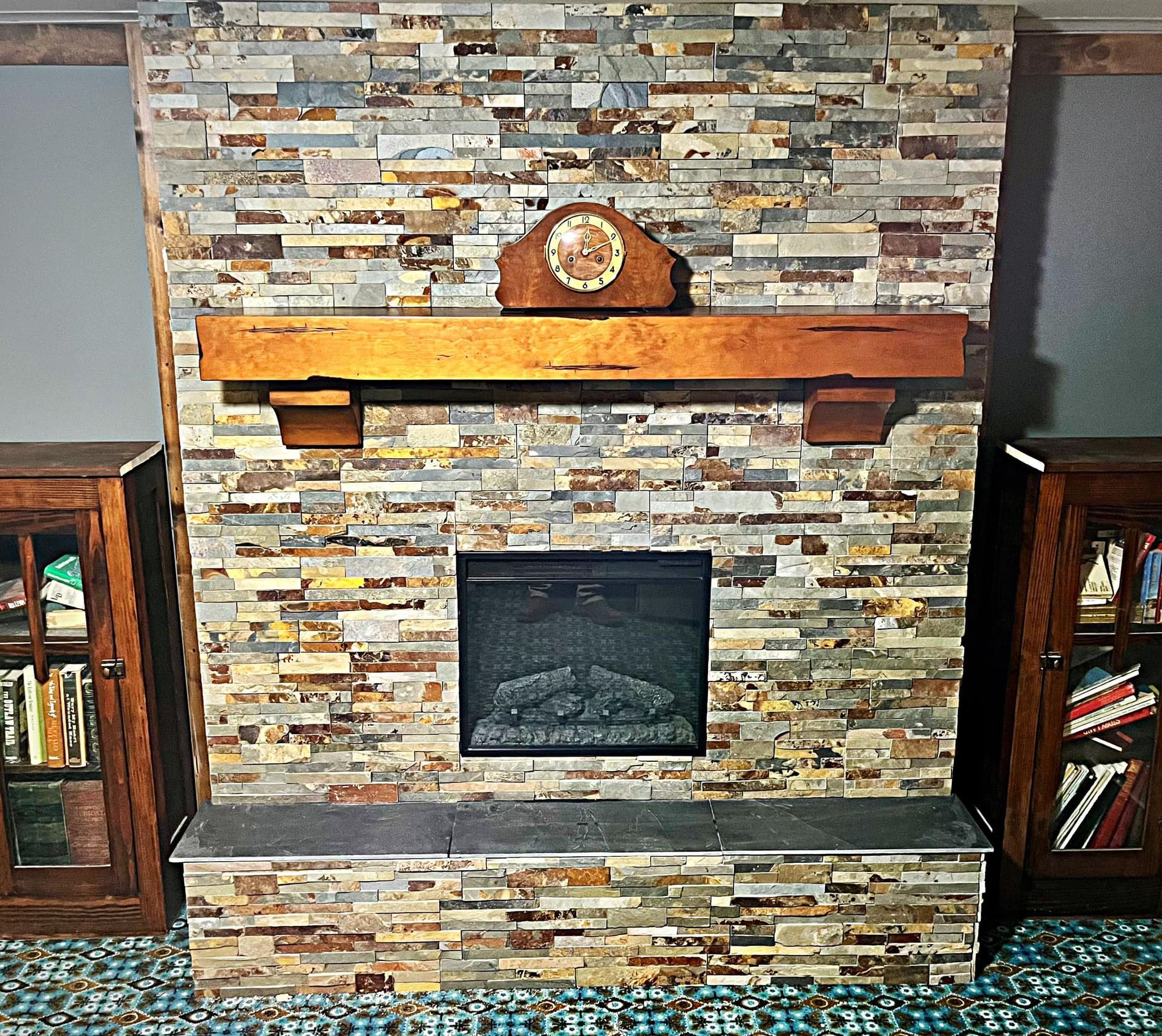 Finished fireplace renovation with stone wall and mantel