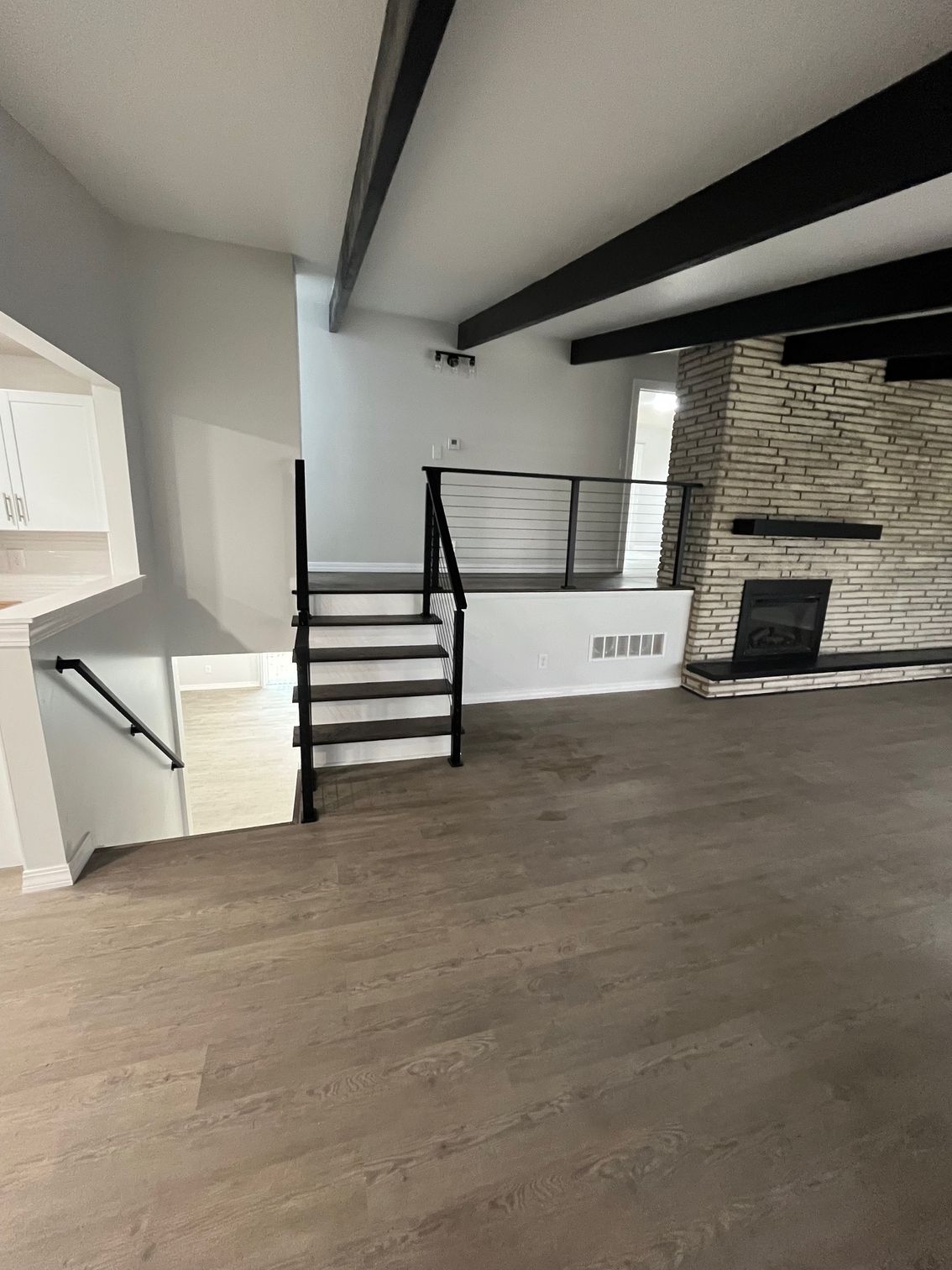 Interior living space with staircase, railing, and flooring installation