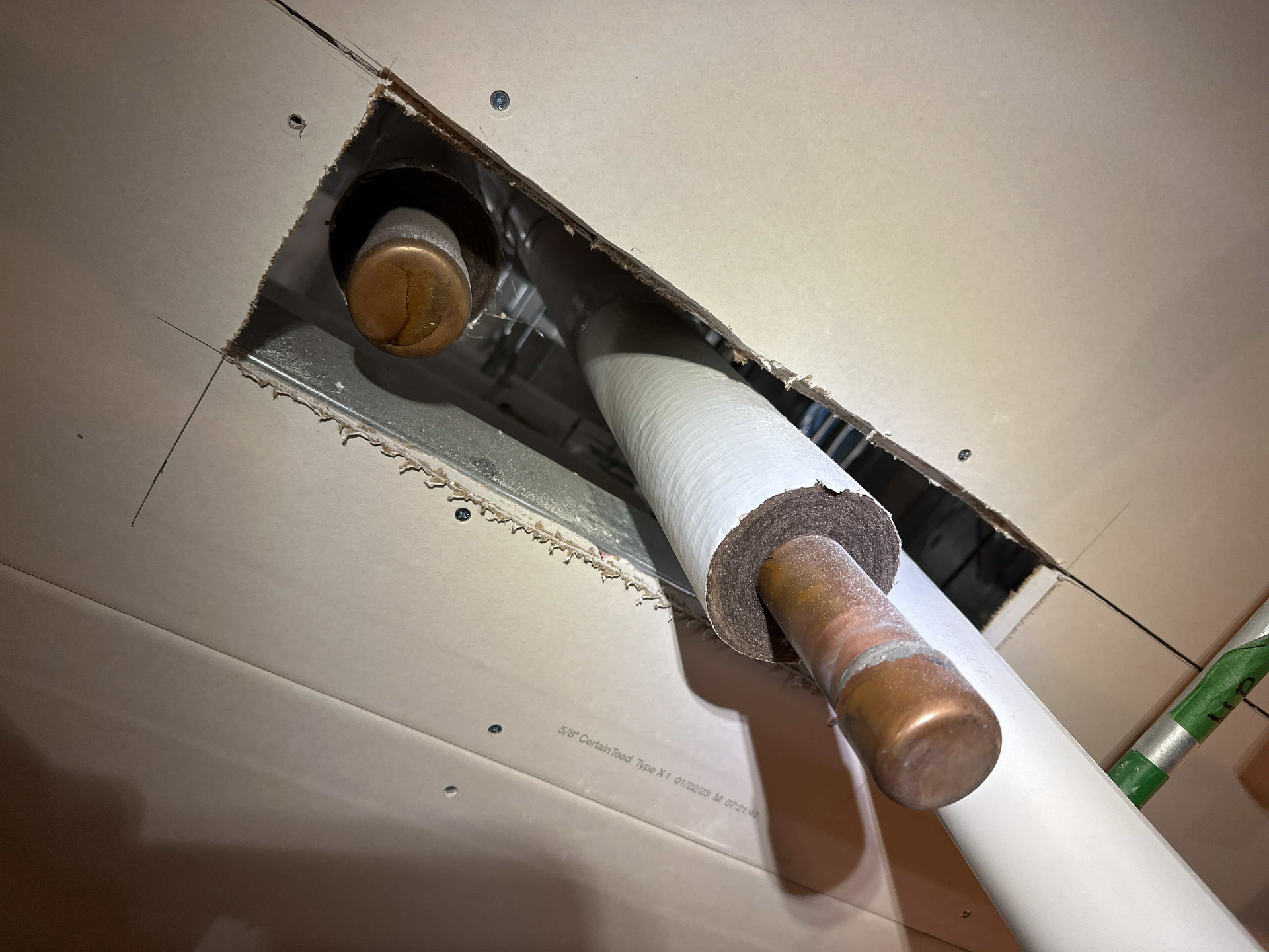 Un tuyau en cuivre sort d'un trou dans le plafond.