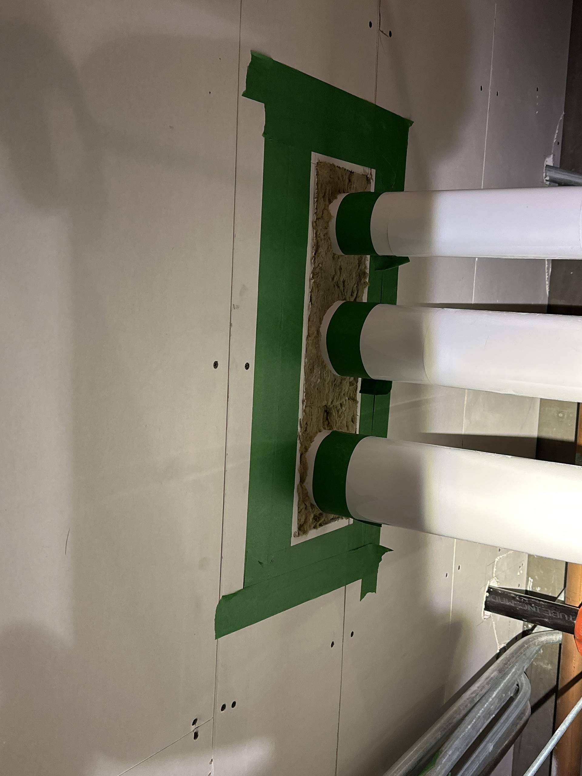 Un ruban vert est utilisé pour sceller un trou dans un mur.