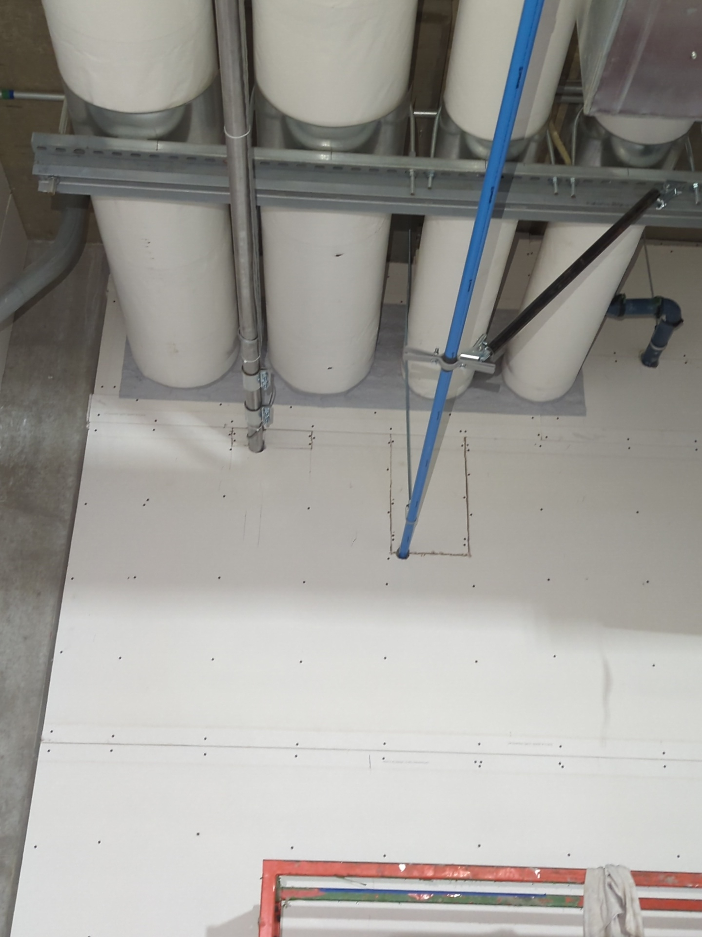 Un tas de tuyaux blancs pendent du plafond