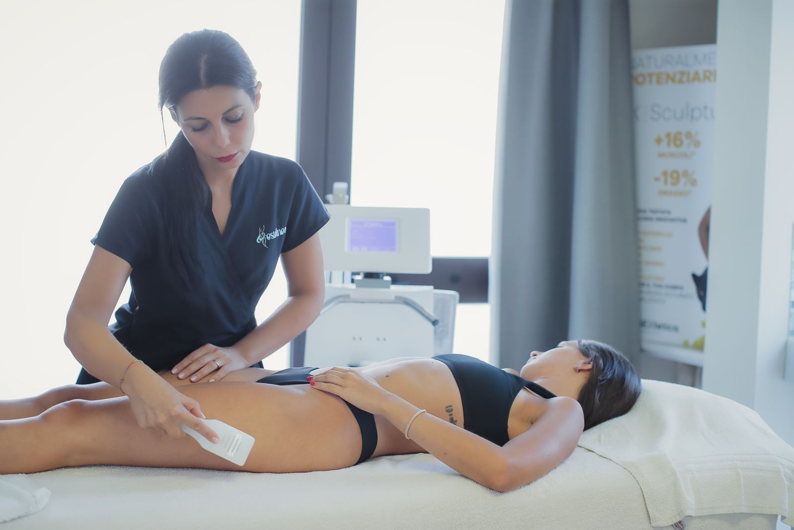Una massaggiatrice applica un trattamento a un cliente sdraiato su un lettino da massaggio in una sala spa.