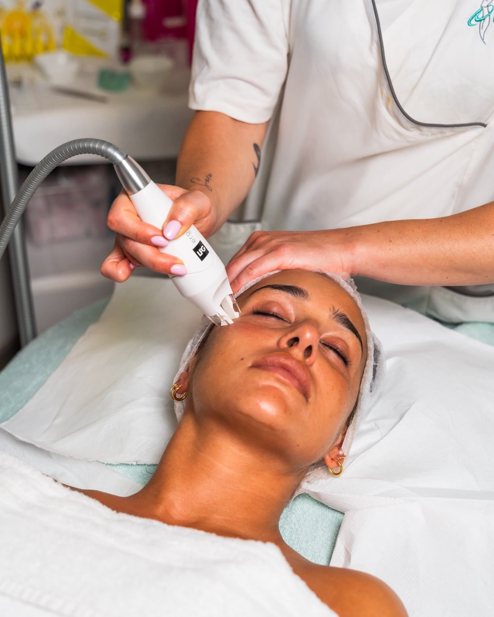 Trattamento viso in una spa, con un'estetista che applica un dispositivo portatile sul viso di una donna.