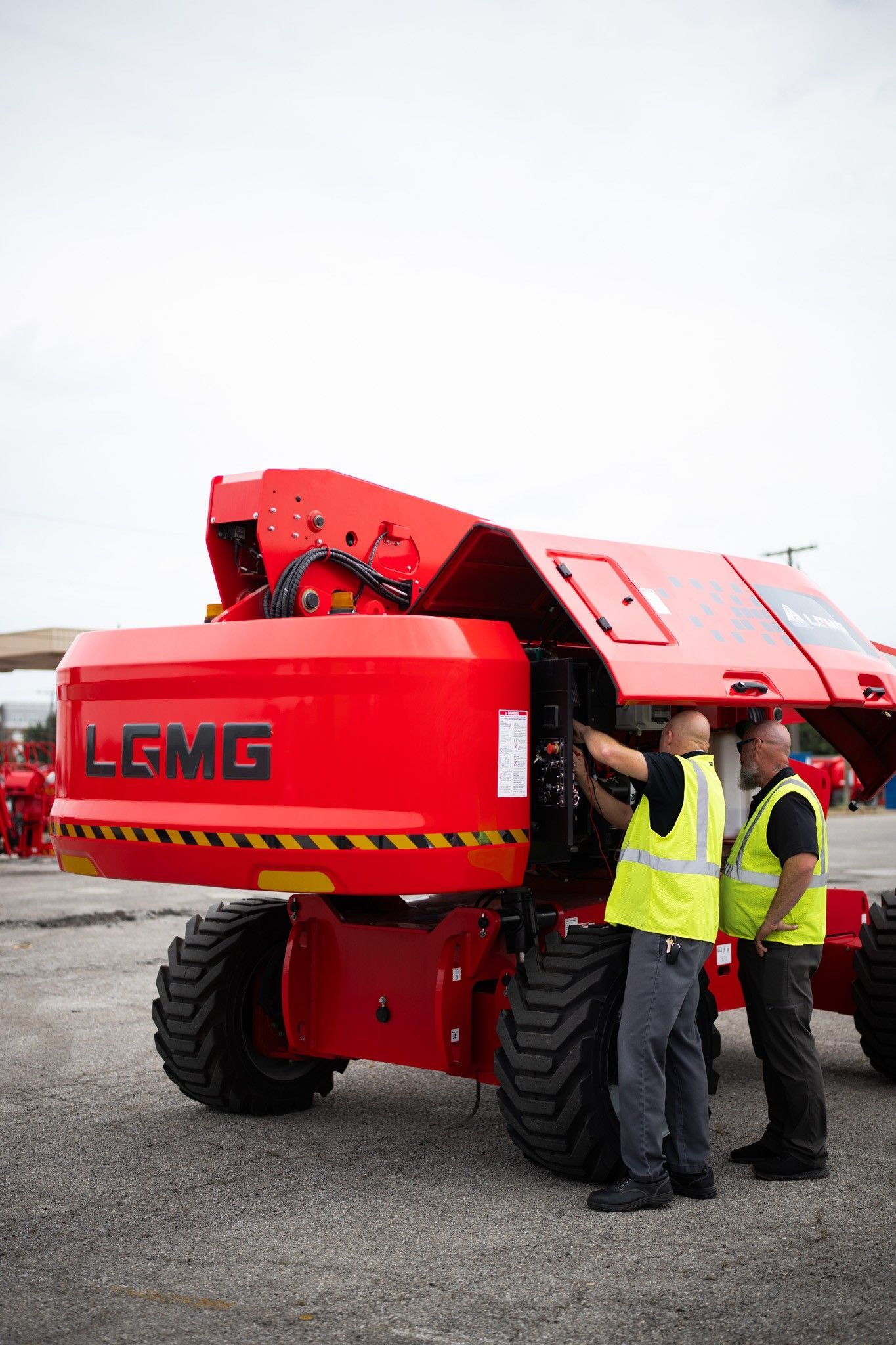 Construction equipment display booth with red machinery, LCMG sign in a warehouse with boxes