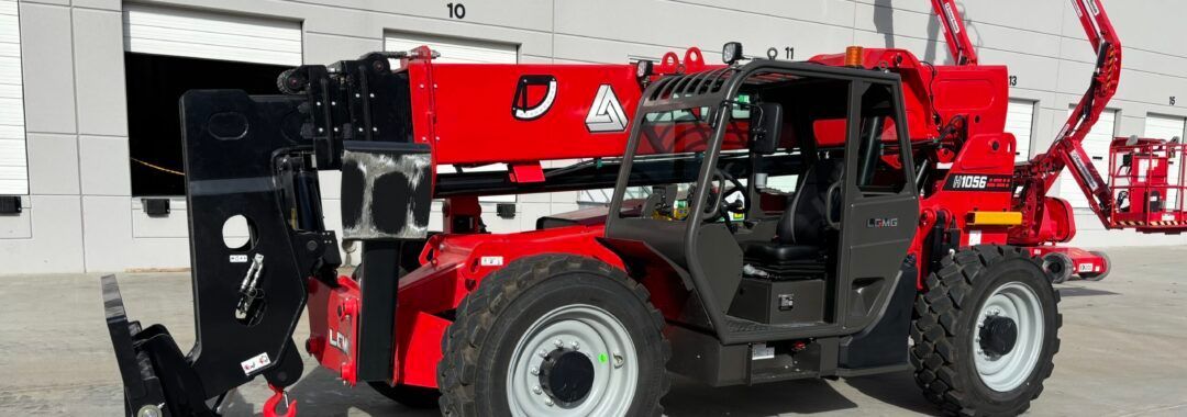 Red construction forklift with black attachments parked on a gray surface in front of white building.