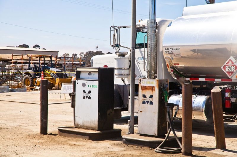 A tanker truck is parked at a gas station.