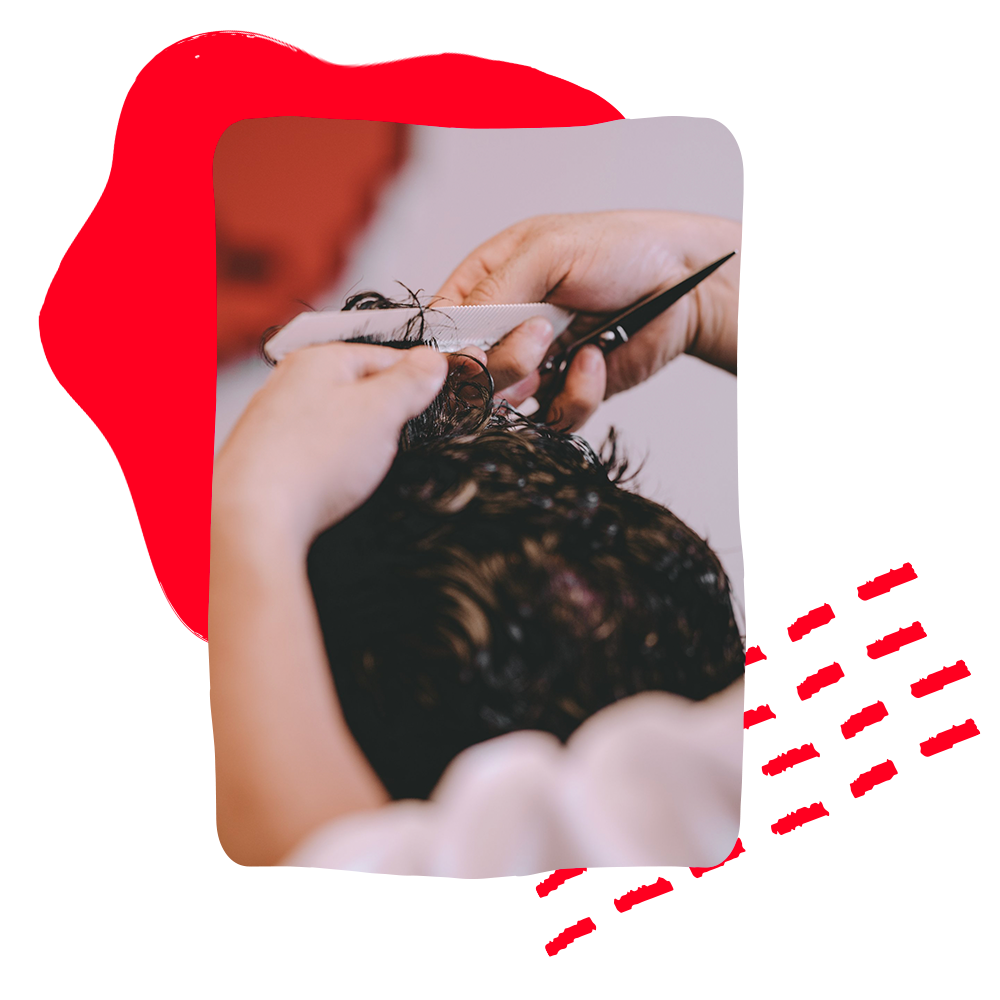 A person is getting their hair cut by a hairdresser