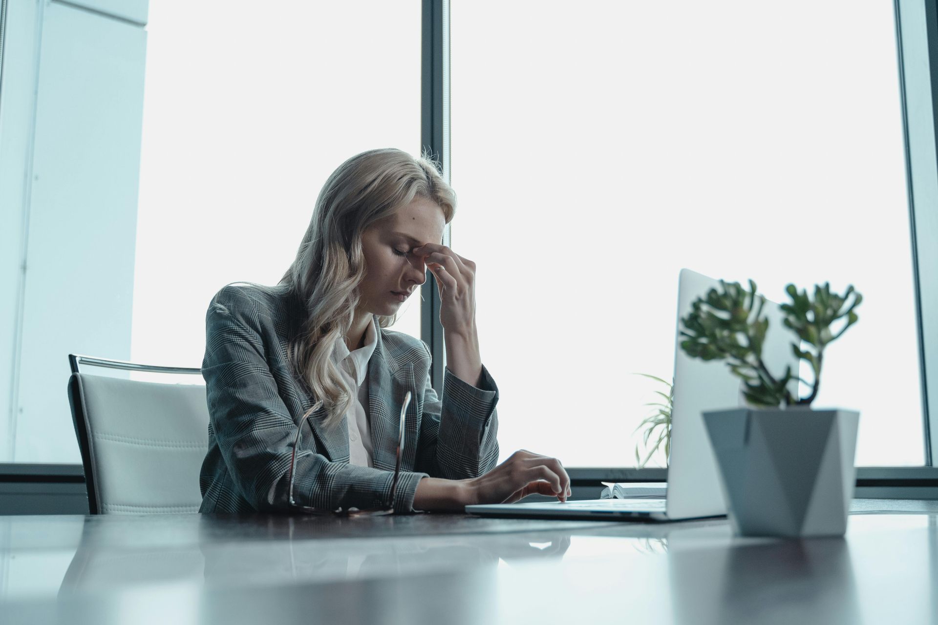 Young professional experiencing stress over missed student loan payments at office desk