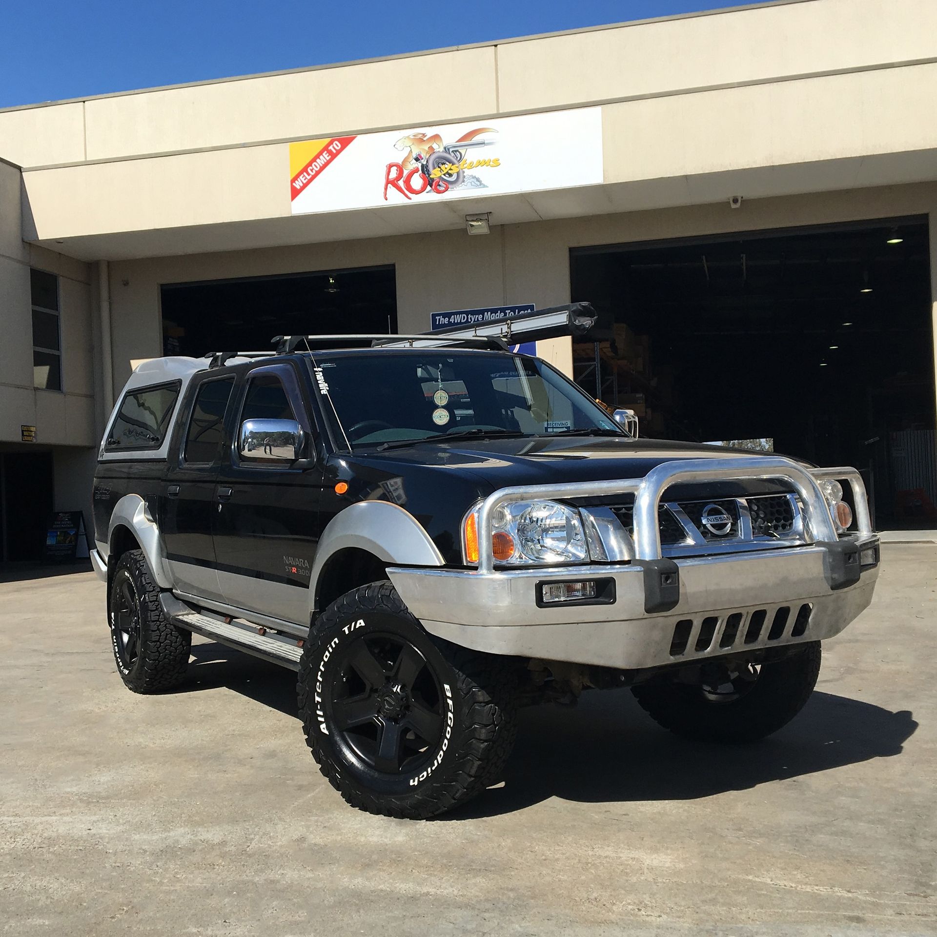 A Black Nissan Truck is Parked in Front of a Building — Practic Automotive Services In Woonona, NSW