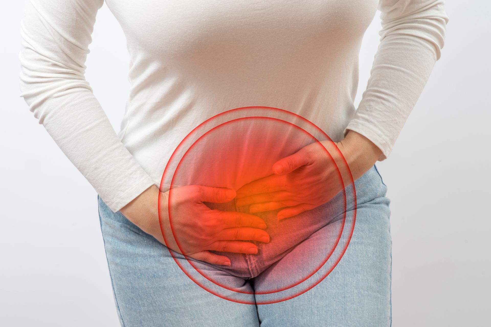 Person holding lower abdomen with red pain highlight over pelvic area