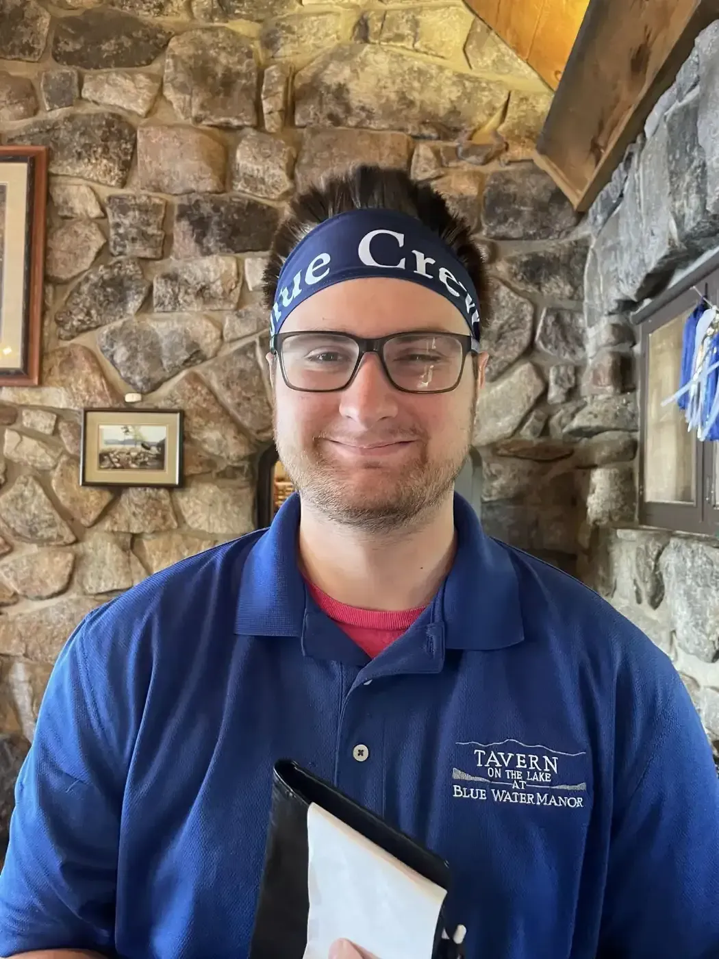 A man wearing a headband and glasses is holding a wallet.