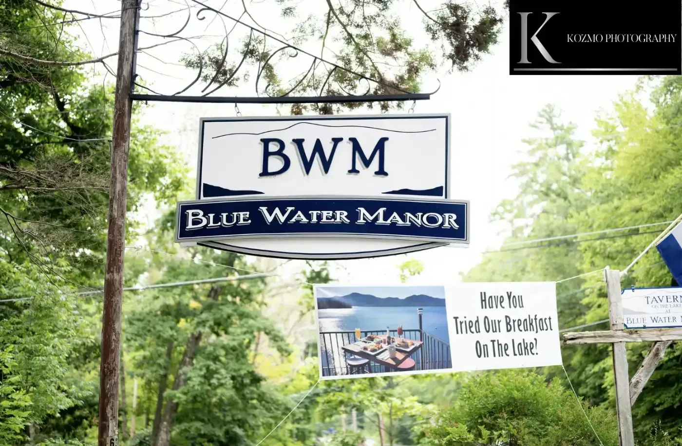 A sign for bwm blue water manor hangs from a pole