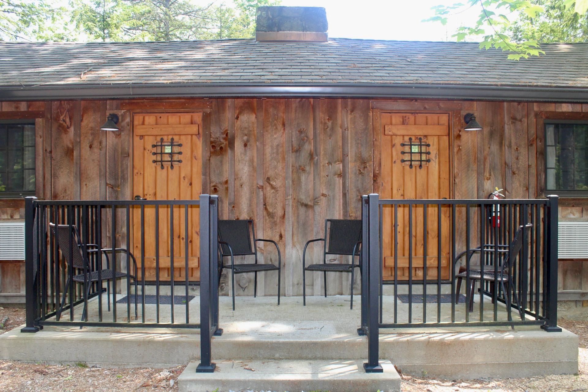 A small wooden cabin with a porch and chairs