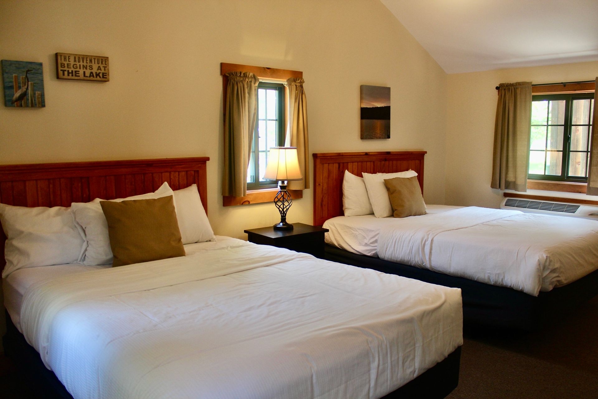 A hotel room with two beds and a window.