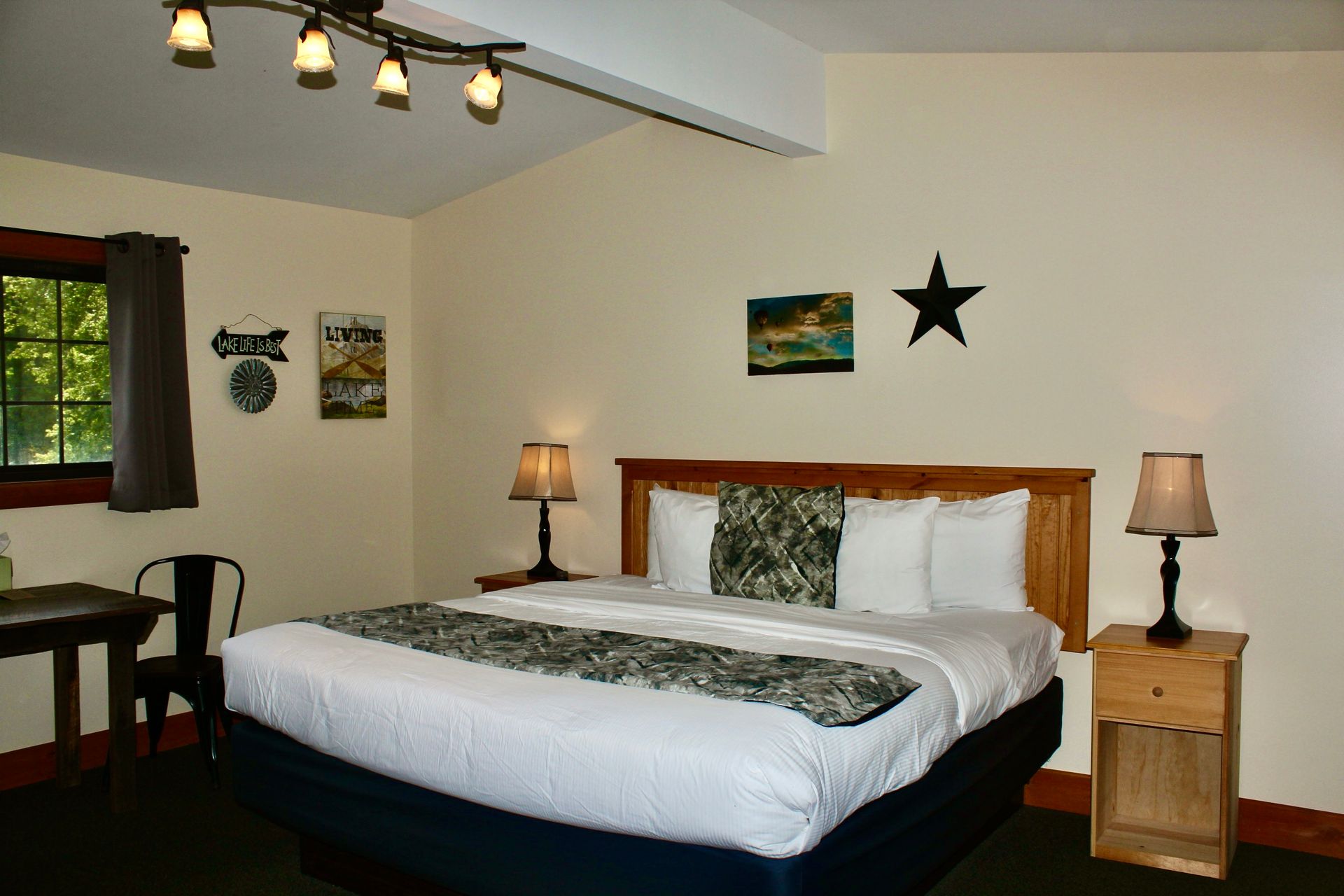 A hotel room with a king size bed and two lamps