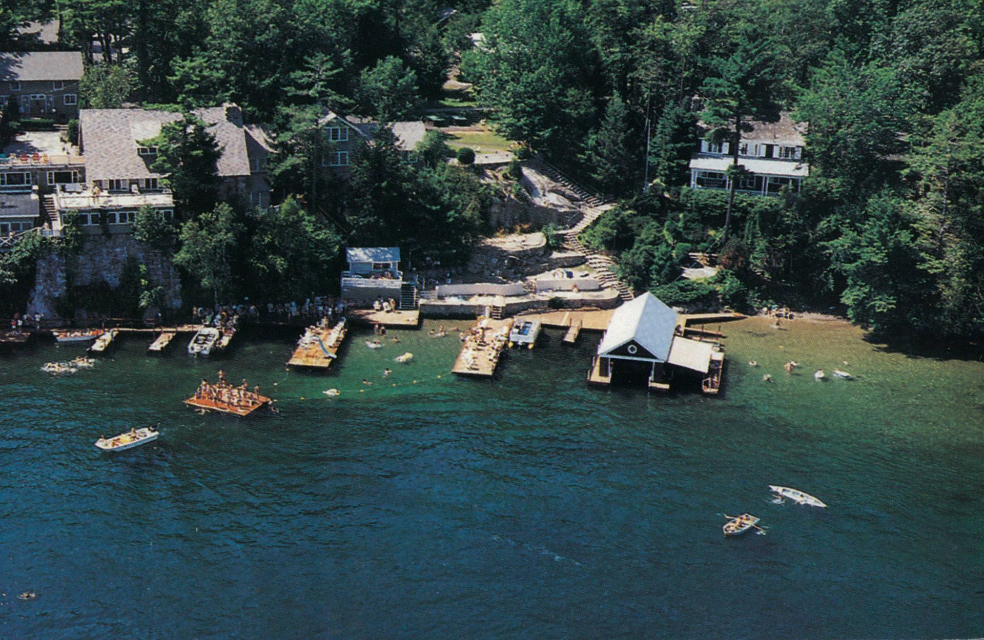 An aerial view of a lake with boats and houses