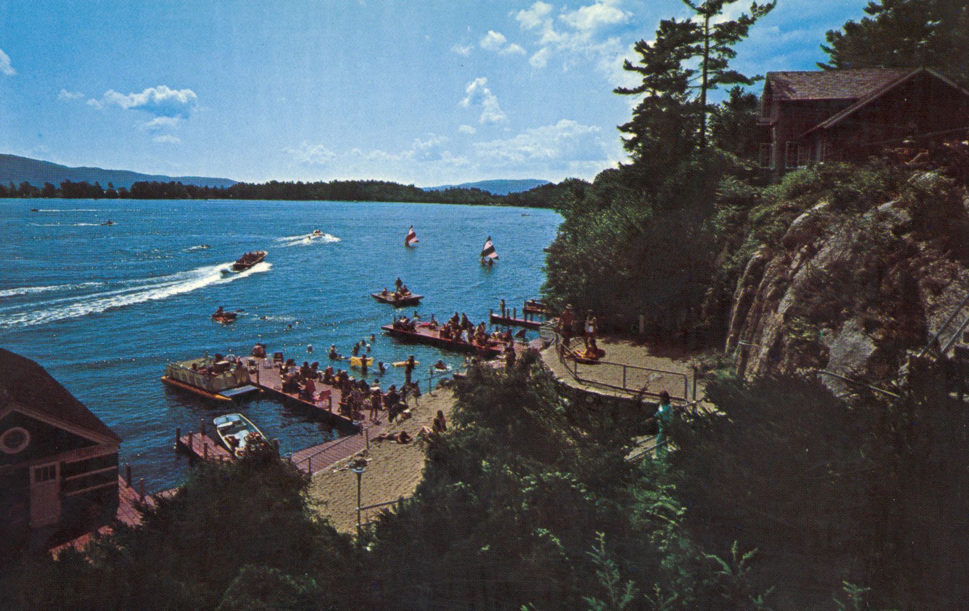A group of people are sitting on a dock near a body of water