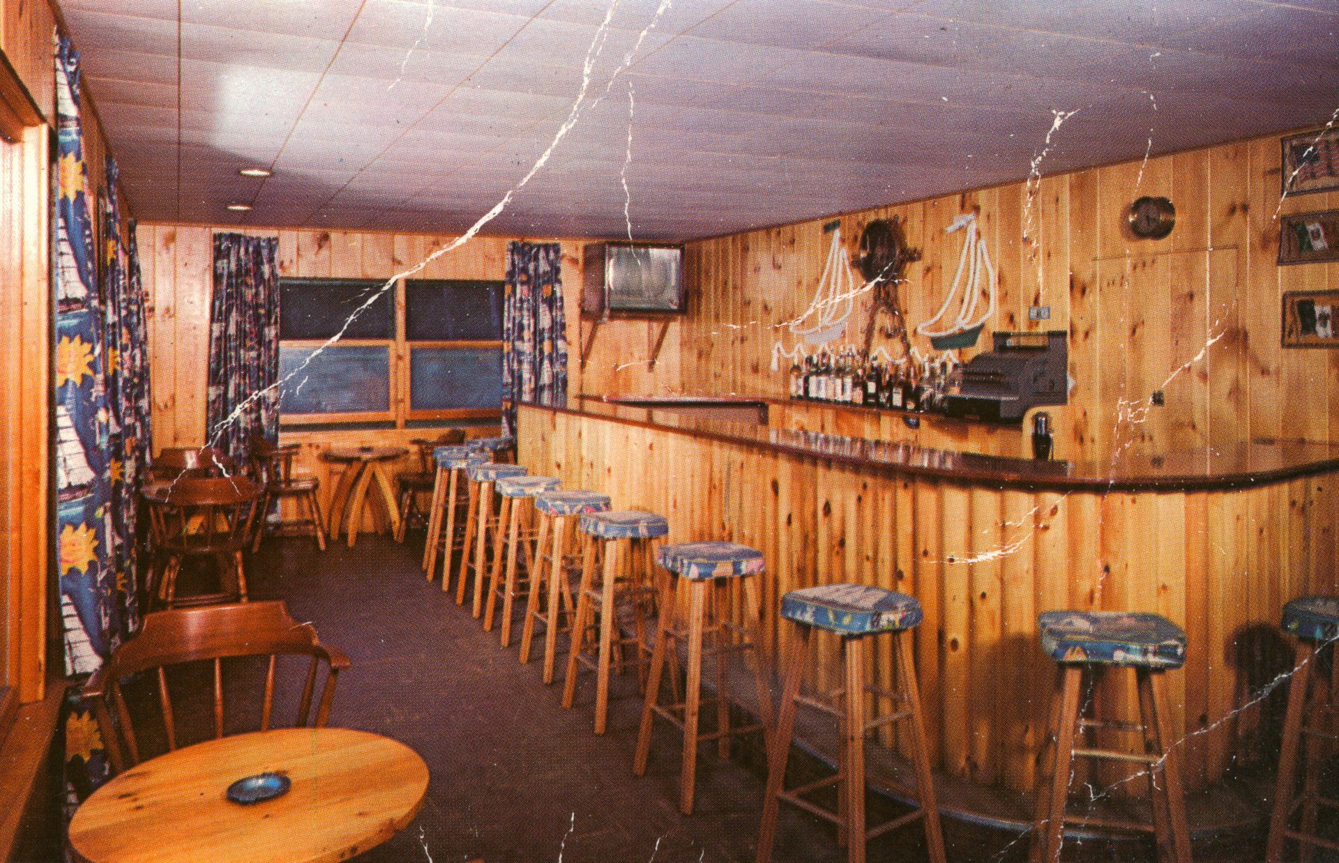 A wooden bar with stools and a round table