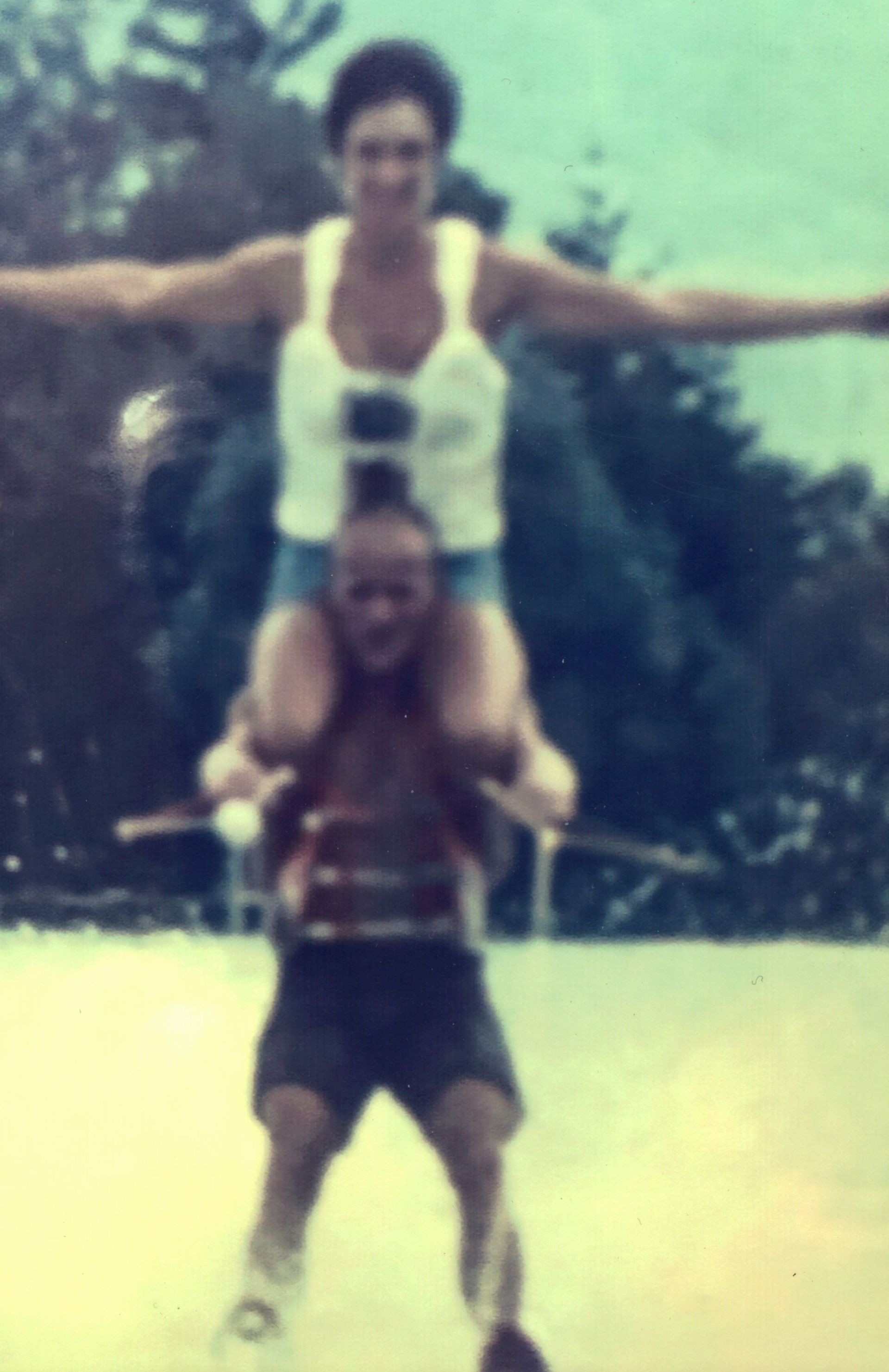 A man is carrying a woman on his shoulder while water skiing