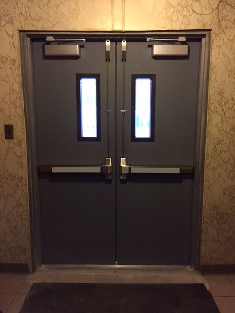 Interior of new fire-rated hollow metal church doors with two vertical rod panic exit devices and two overhead door closers, Bronx NY