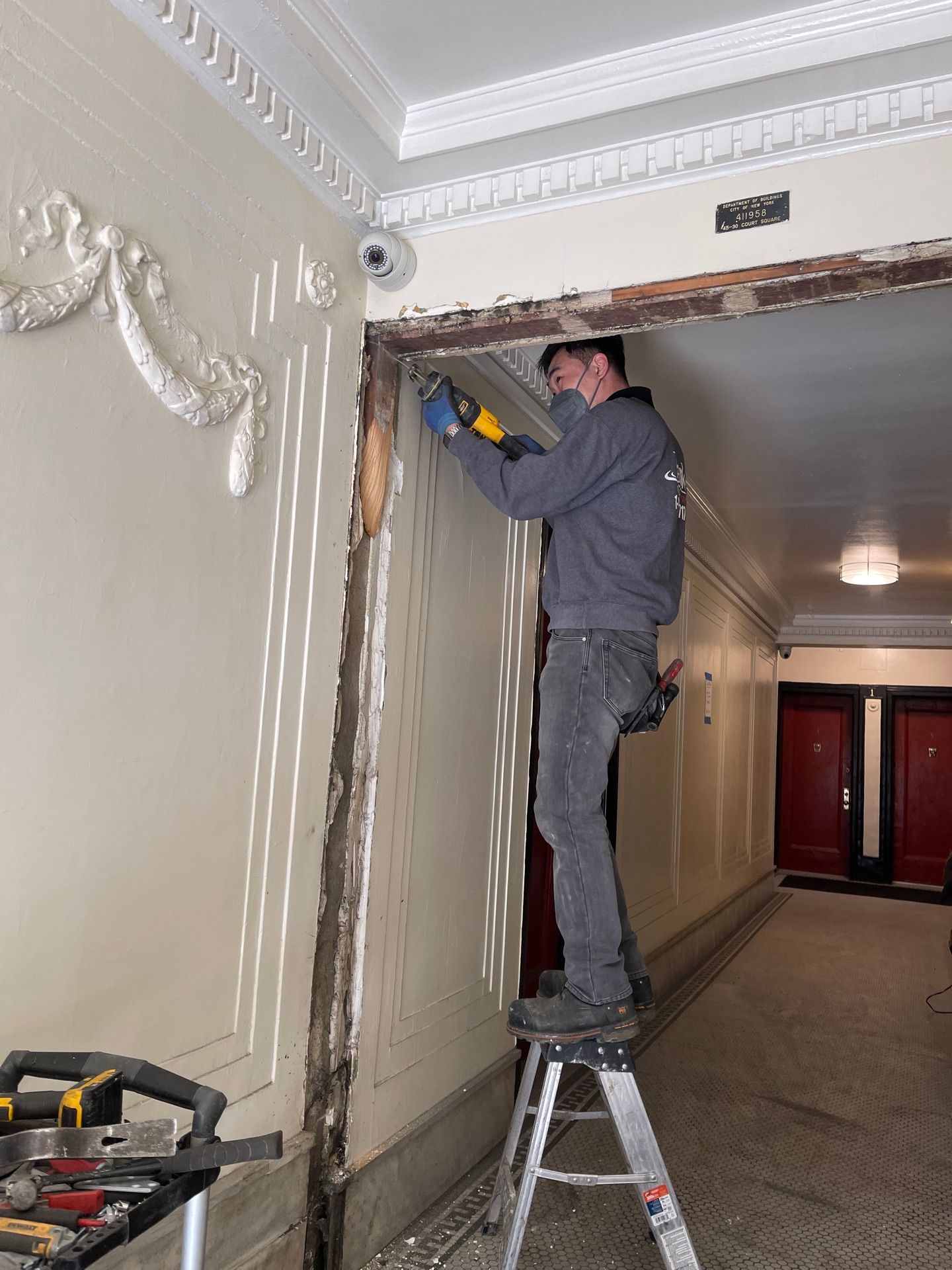 Removing existing door framing at an apartment building in Long Island City, Queens