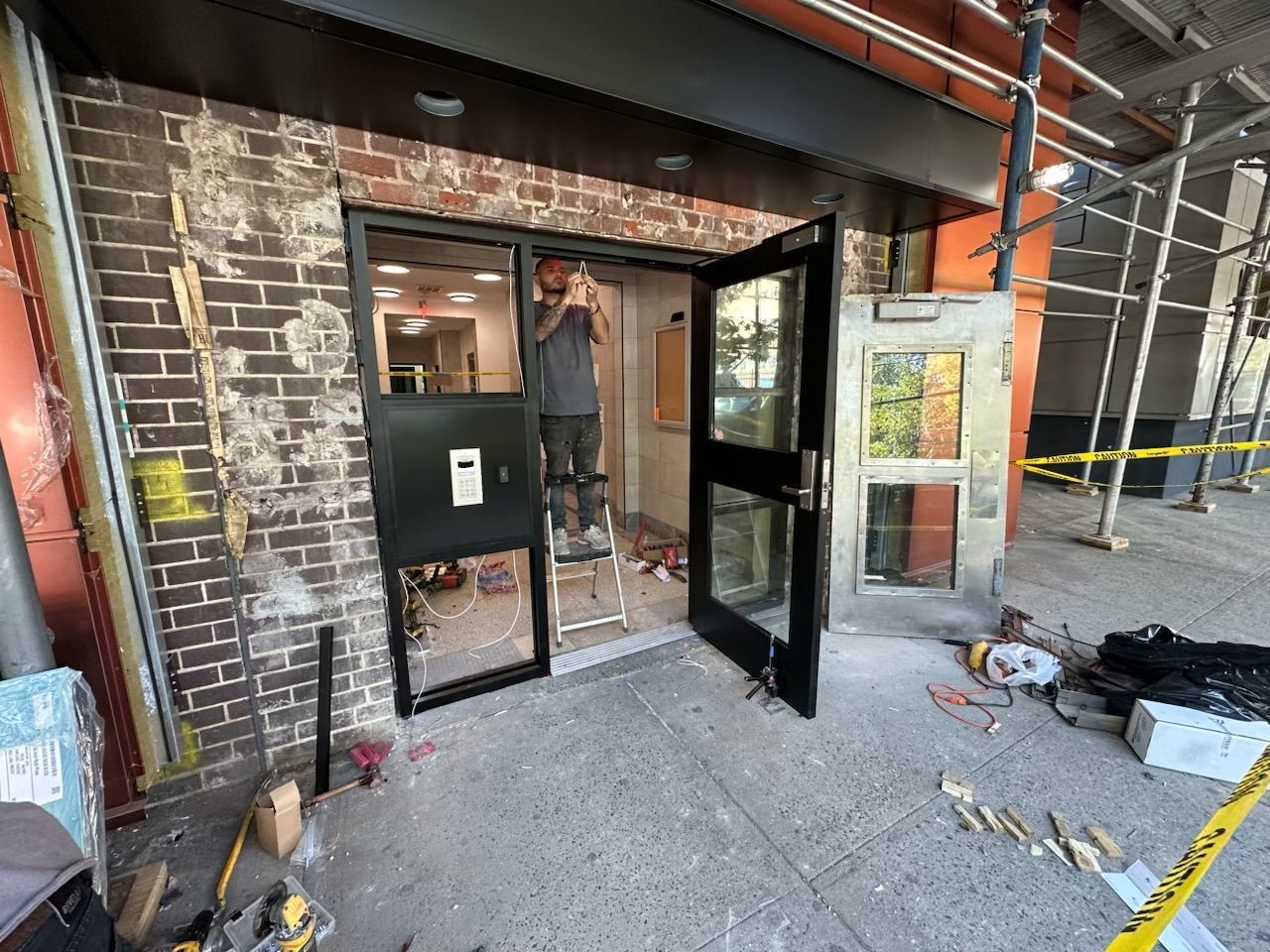 Installing new aluminum storefront door system with control access at apartment building in The Bronx