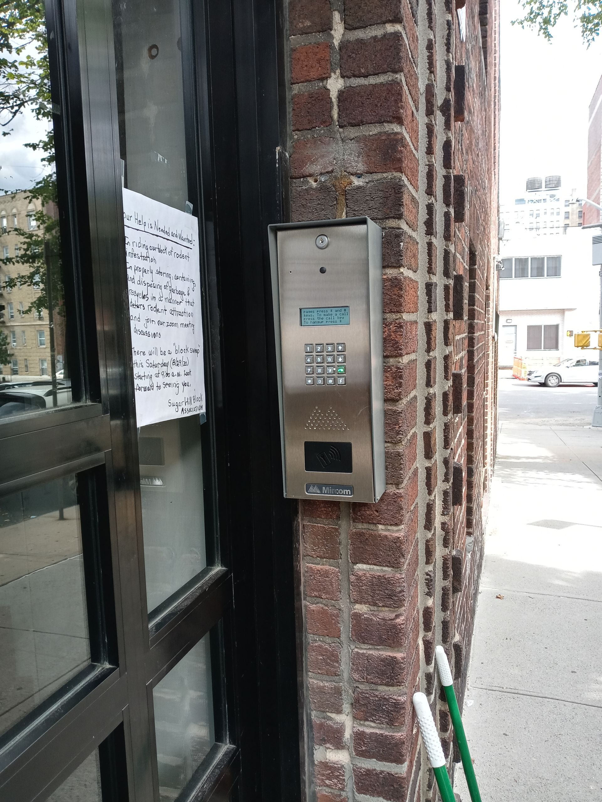 New Mircom intercom system mounted on brick exterior at a multi-tenant building entrance in Hamilton Heights, Manhattan
