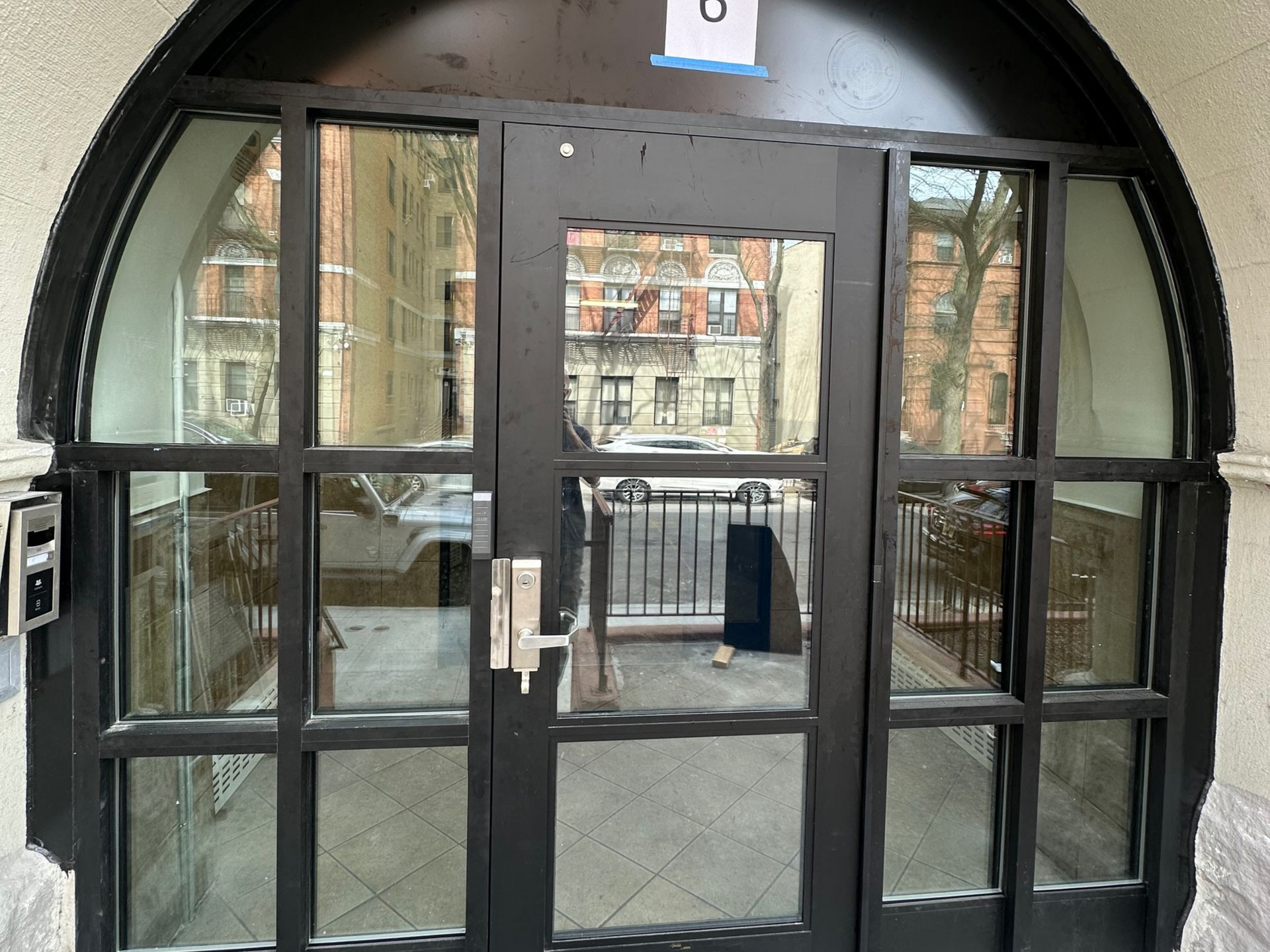completed storefront doors with secure hardware and a custom arch at an apartment building in Brooklyn NY