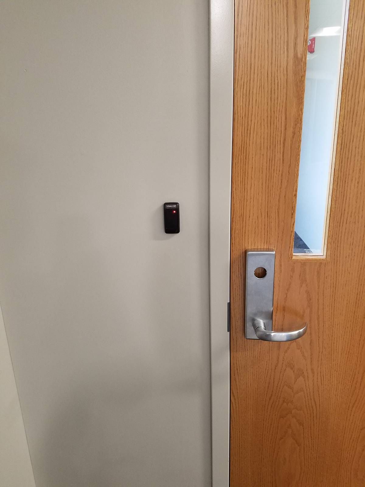 Proximity card reader beside a wood office door with vision lite at a West Orange, NJ church