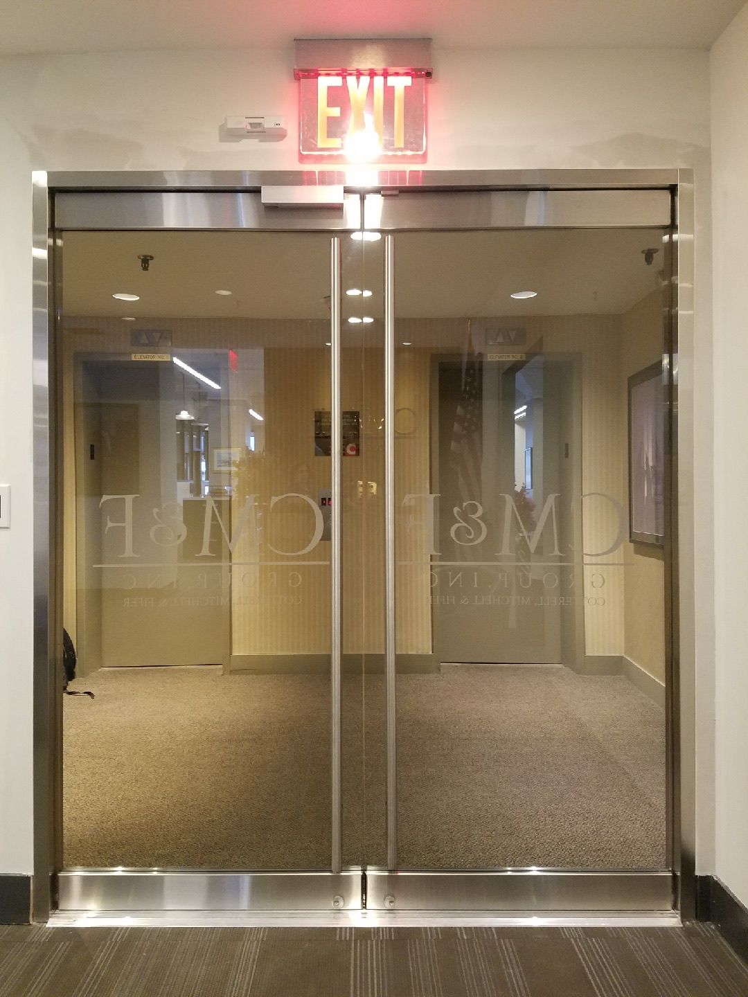 Interior view of completed Herculite glass door installation at CM&F Group office — reception area entrance, Manhattan