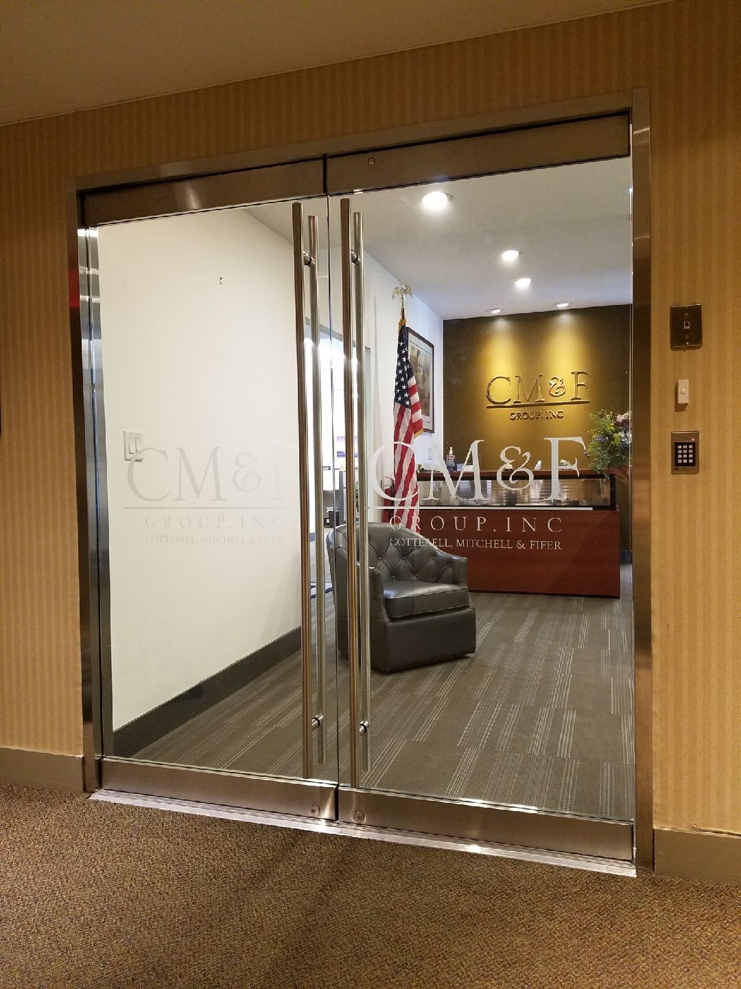 Custom Herculite frameless glass double doors installed at CM&F Group Manhattan office — side angle view
