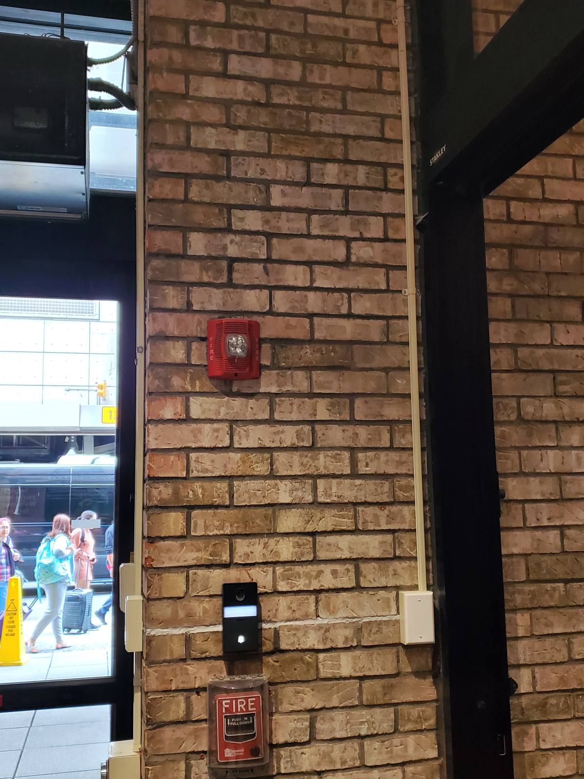 Comelit intercom door station on a brick column inside the entrance of a Midtown Manhattan hotel