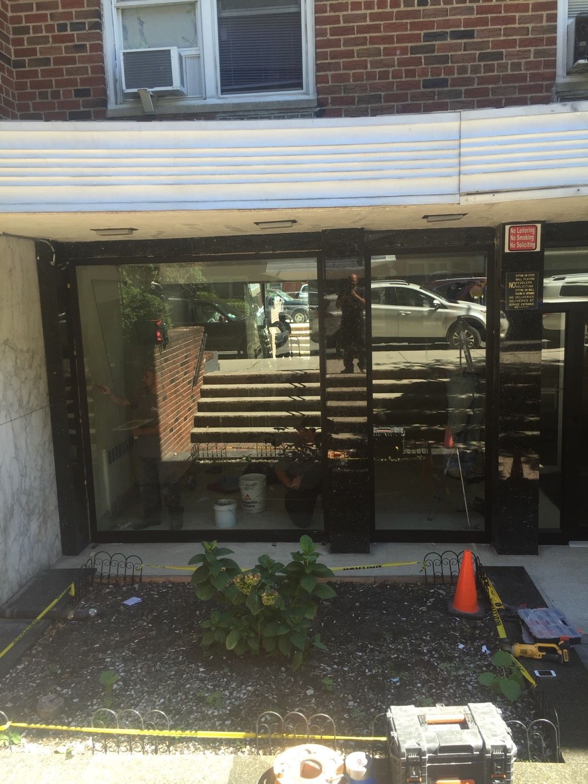 New tempered-glass side lites and black aluminum framing at a Flushing, Queens entrance