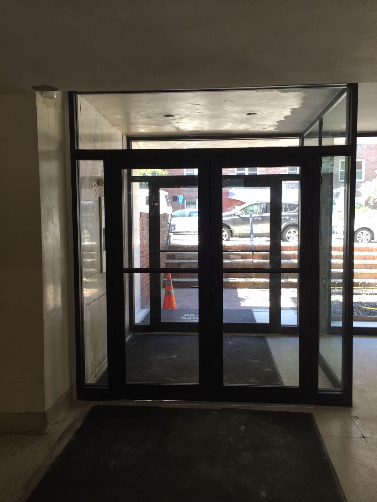New black aluminum vestibule door with commercial hardware at a Flushing, Queens apartment building