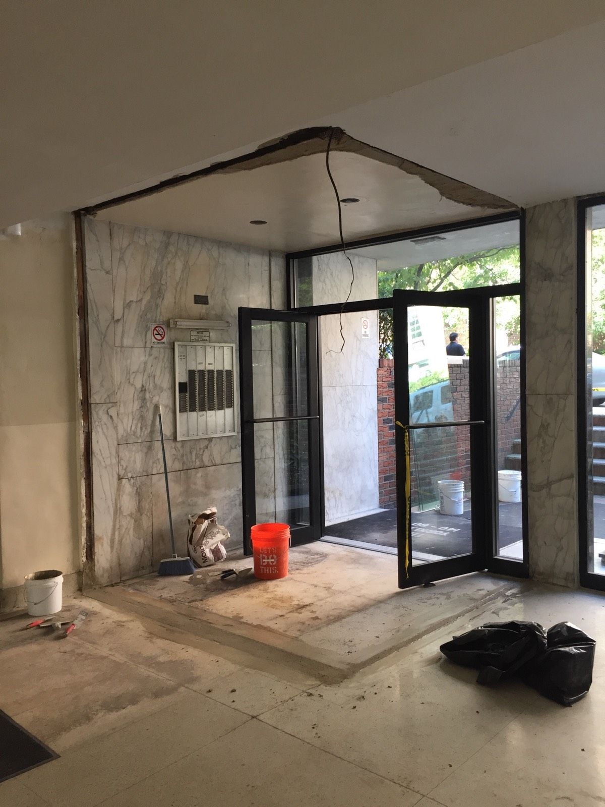 Demolition of aging vestibule framing at a Queens multi-tenant building