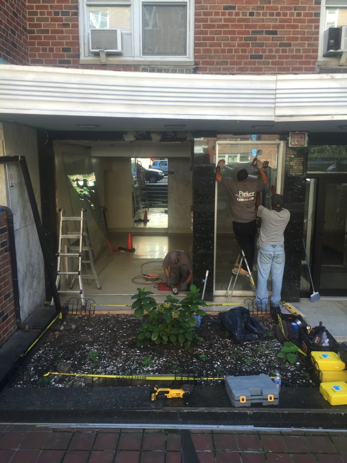 Removing original side-lite panels during vestibule installation in Flushing, Queens