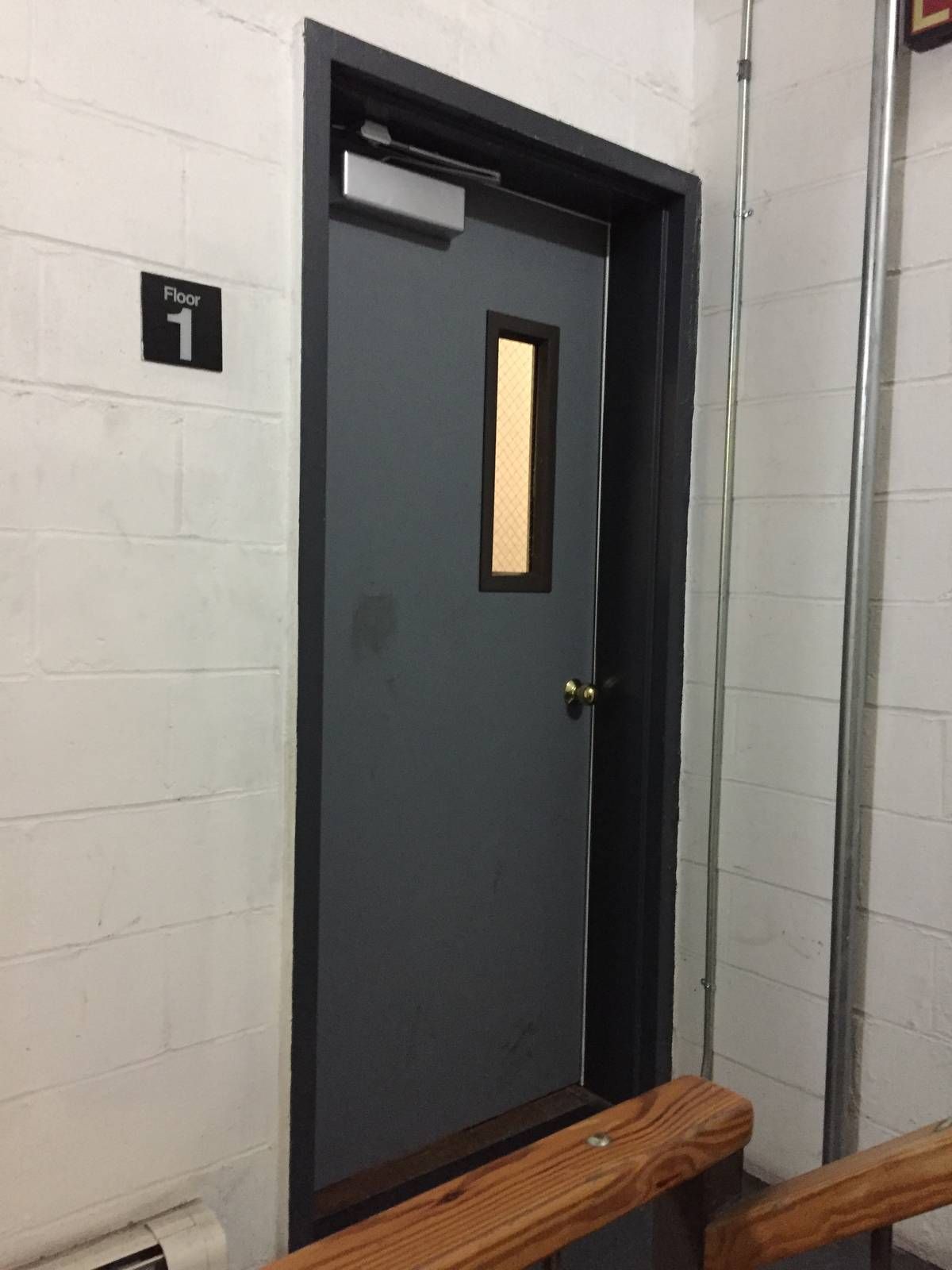Completed hollow metal Stair A exit door at the first-floor landing in a Hell's Kitchen apartment building