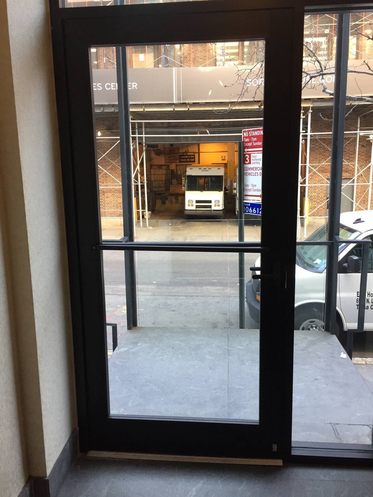 Narrow-stile aluminum entrance door with glass sidelight at a Hell's Kitchen apartment building
