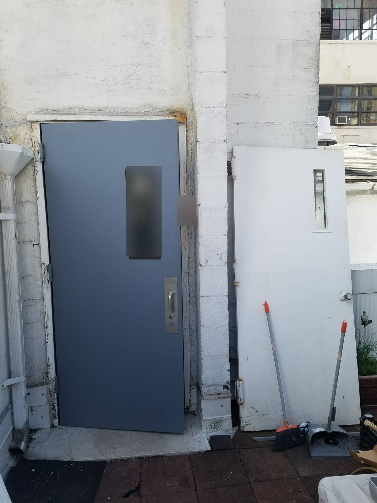 New gray hollow metal roof door installed beside the old white roof door it replaced, Hell's Kitchen NYC