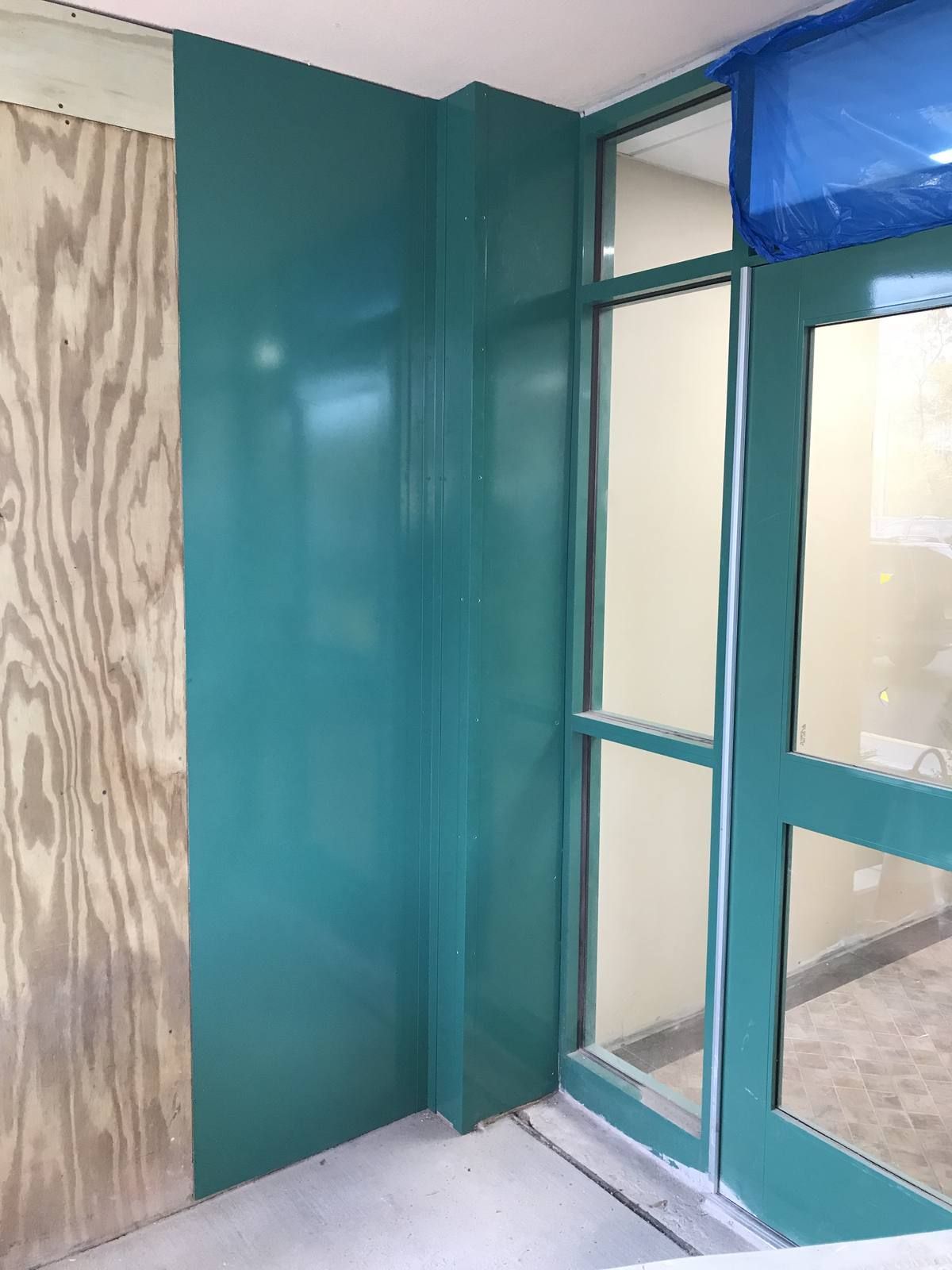 Interior vestibule framing and column cladding mid-installation at 175-195 First Street, Newark NJ