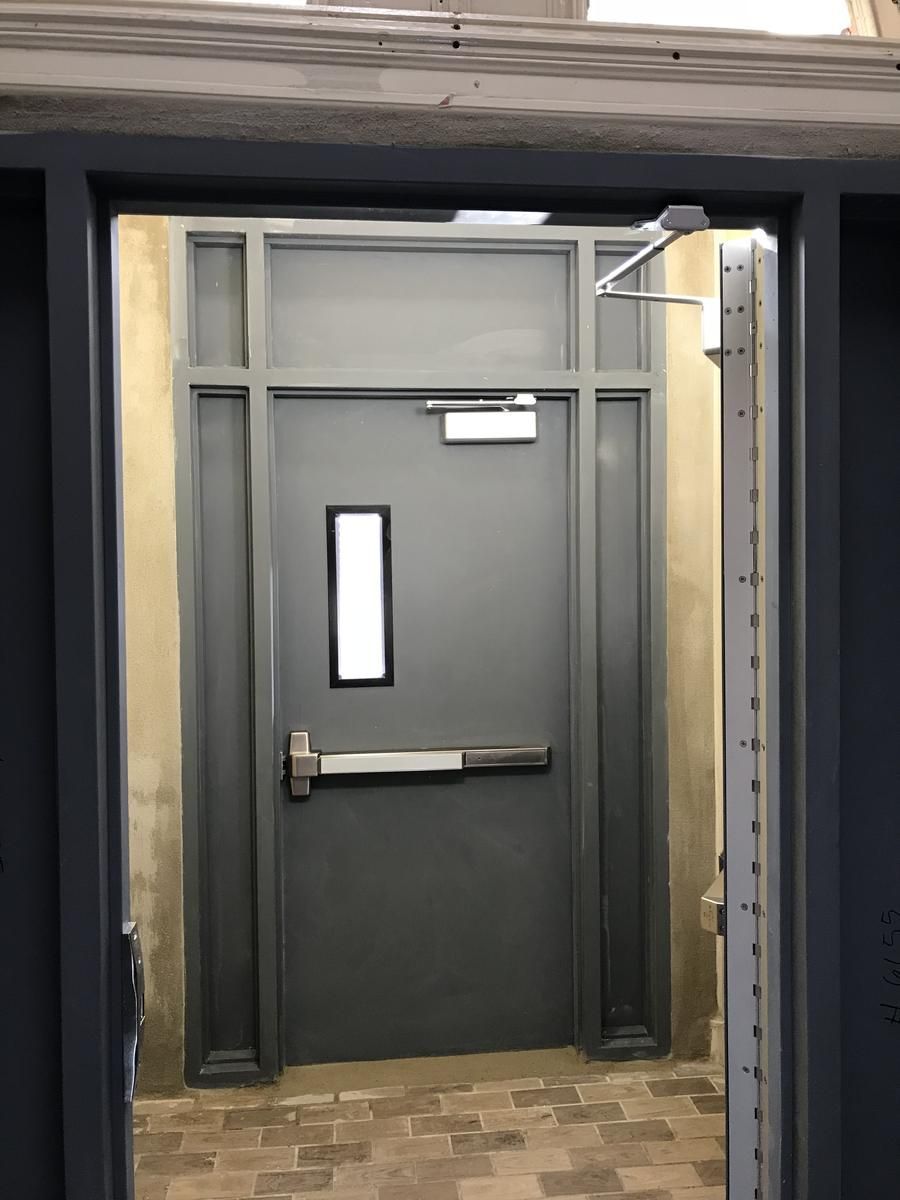 Hollow metal vestibule door with a rim exit device, vision lite, and closer at a nonprofit building in Harlem