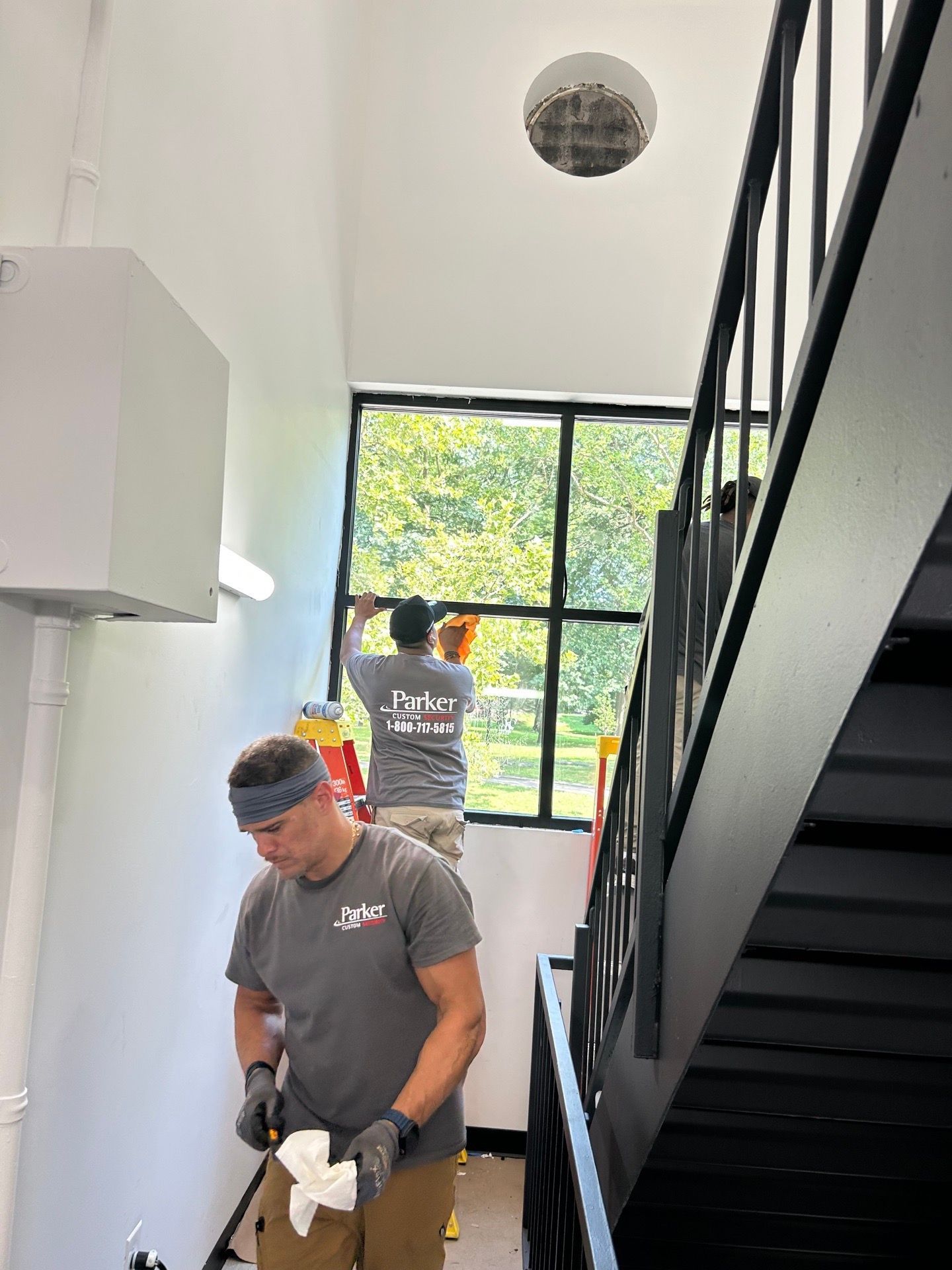 Parker Custom Security crew installing an energy-efficient window in the stairwell of a Bronx apartment building
