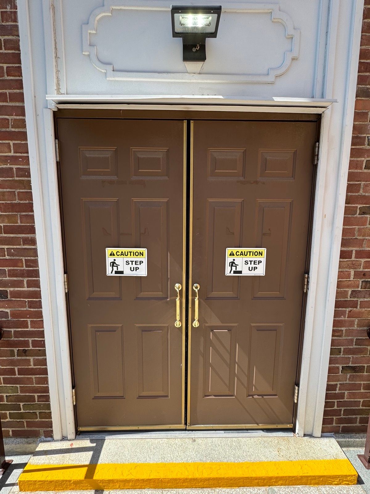 Exterior double entry doors with brass hardware at St. Clare's Church in Staten Island, NY