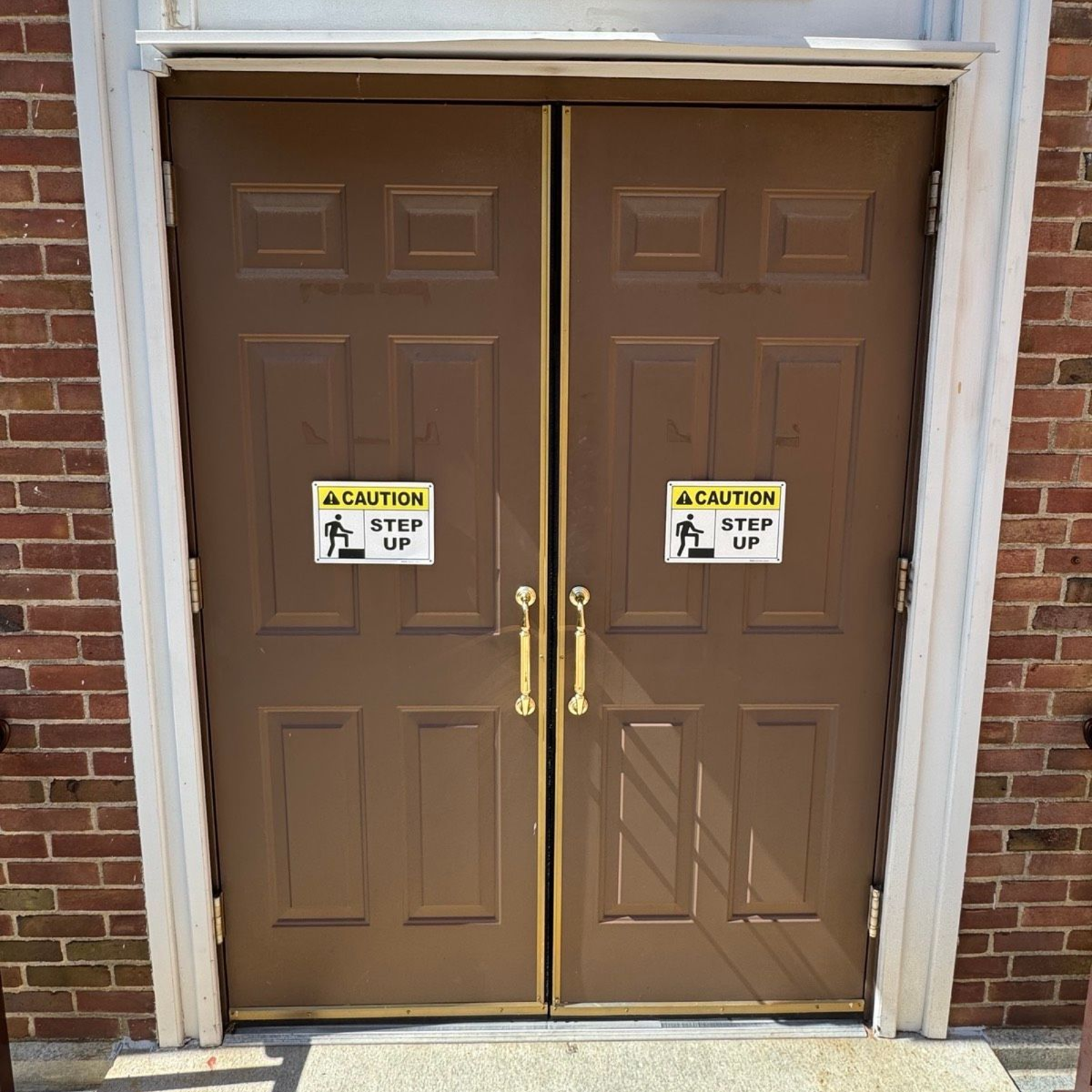 Exterior double entry doors with brass hardware at St. Clare's Church in Staten Island, NY