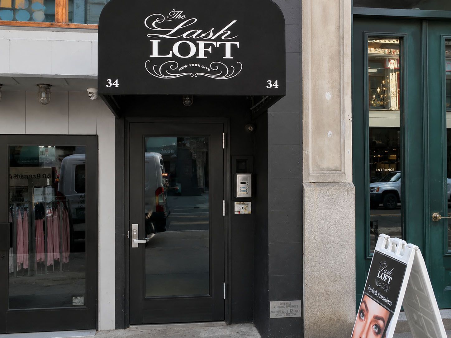 Commercial aluminum and glass storefront entrance door with intercom and card-reader entry panel at a retail business in Manhattan, NY