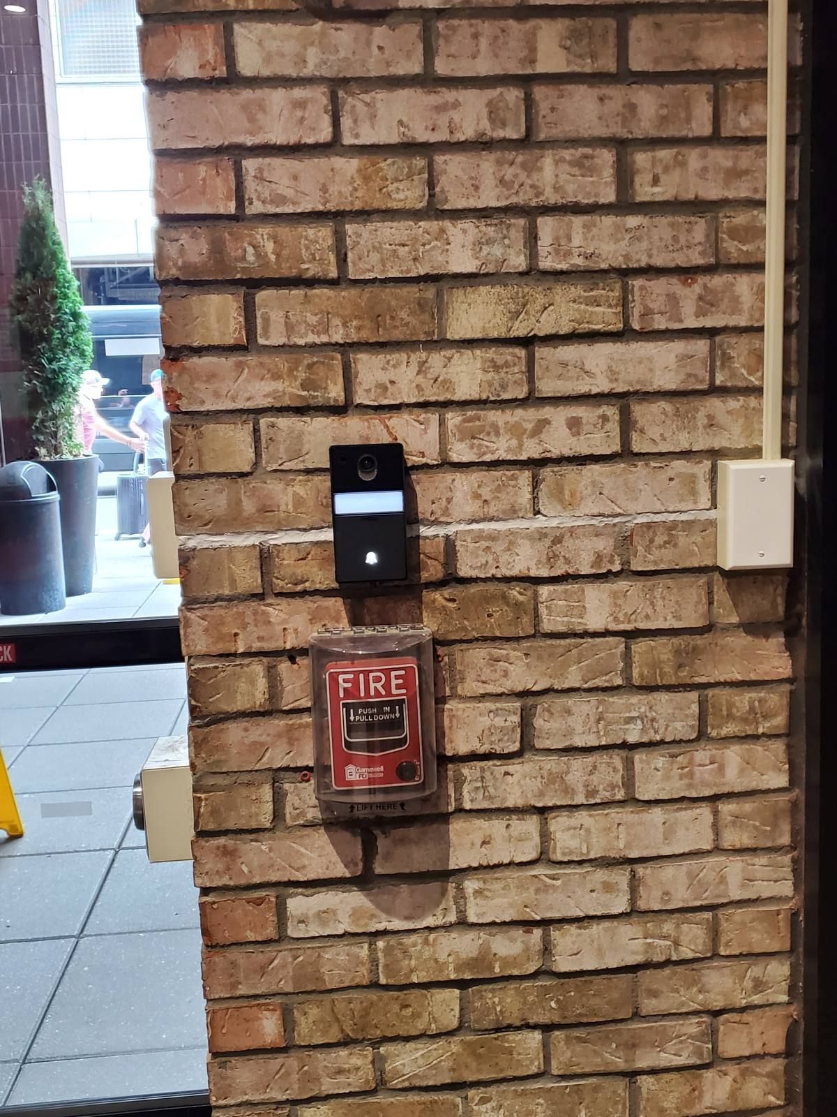 Comelit video intercom door station on an exposed brick column at a Times Square hotel entrance, 350 West 40th Street, NYC