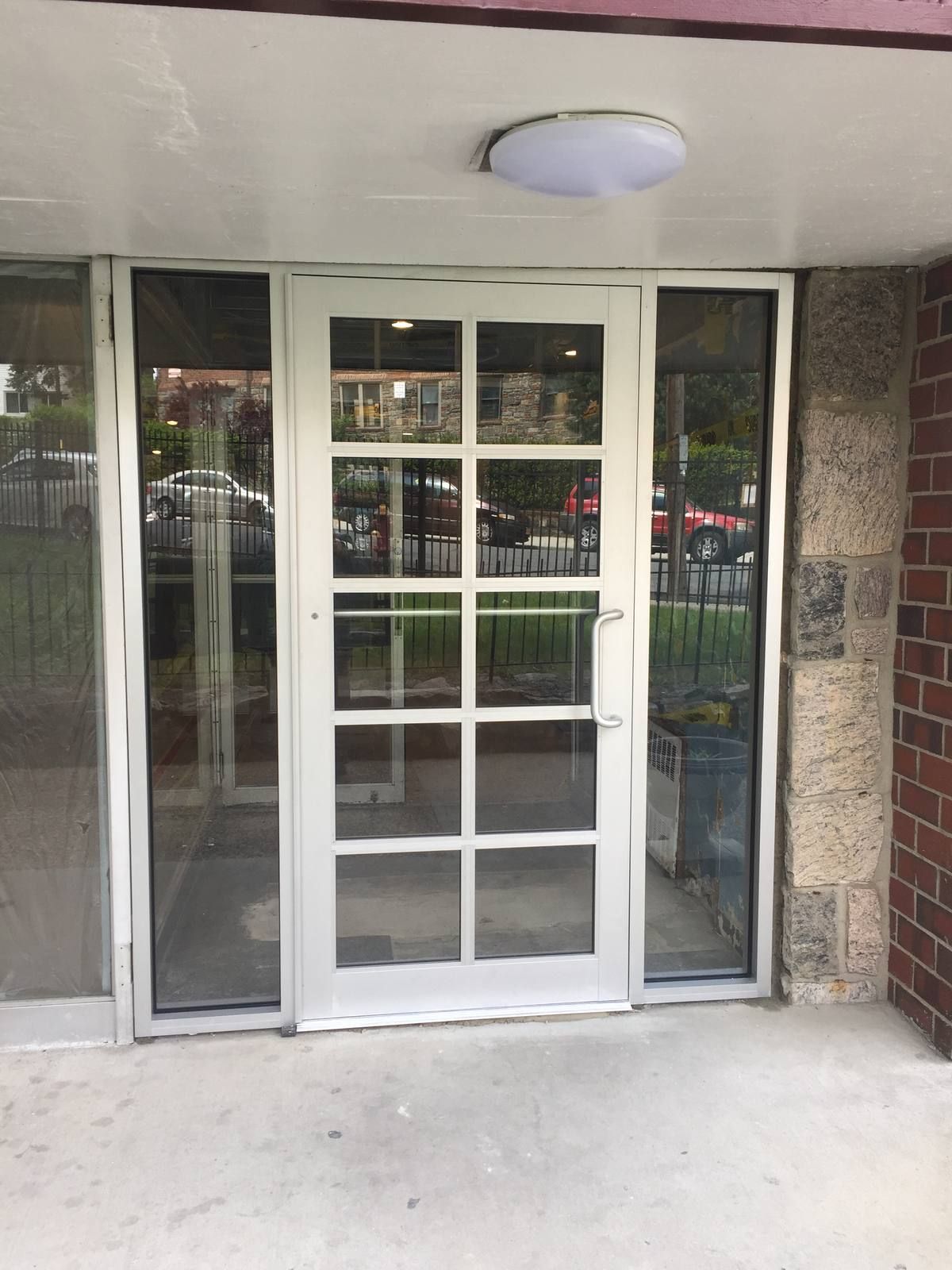 New clear aluminum entrance door with colonial grid and glass sidelites at 101 Highland Avenue, Yonkers, NY
