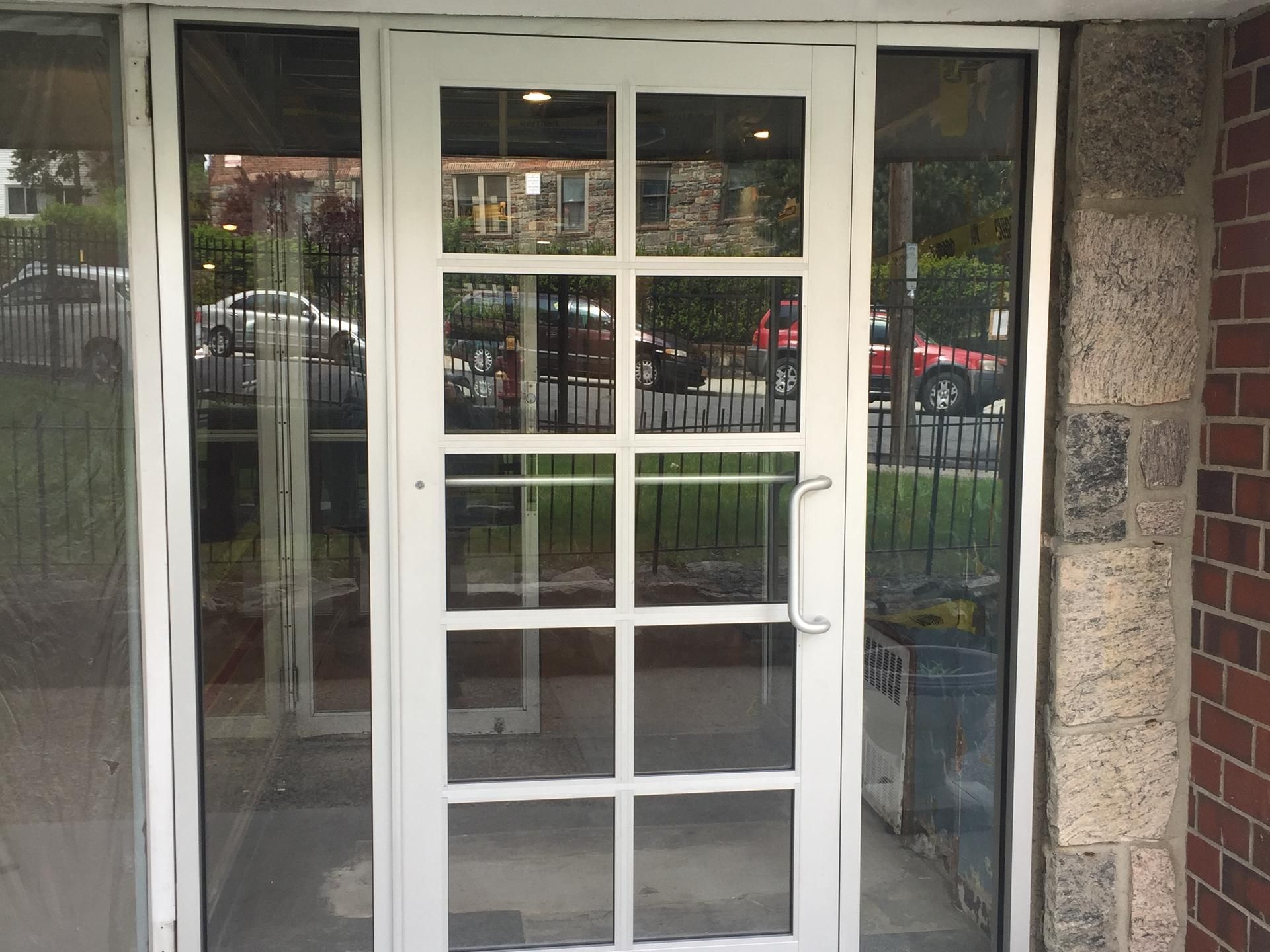 New clear aluminum entrance door with colonial grid and glass sidelites at 101 Highland Avenue, Yonkers, NY