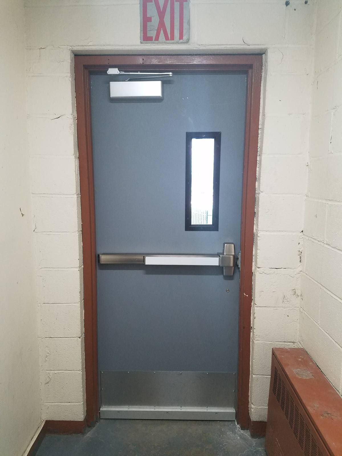 New gray hollow metal exit door with panic bar, closer, vision lite, and kick plate in Yonkers, NY